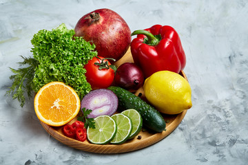 Still life of fresh organic vegetables on wooden plate over white background, selective focus, close-up