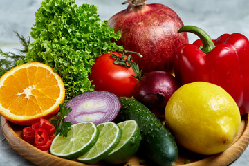 Still life of fresh organic vegetables on wooden plate over white background, selective focus, close-up