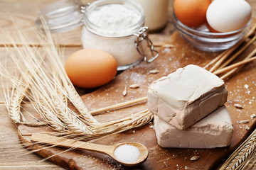 Fresh yeast and ingredients for Easter baking on rustic kitchen background.