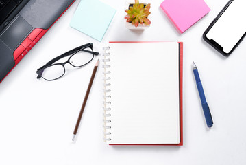 Top view or Flat lay style for business with copy space of workspace with laptop , pen  pencil , notebook , cup of coffee , sticky note eyeglasses and mobile phone isolated on white table background