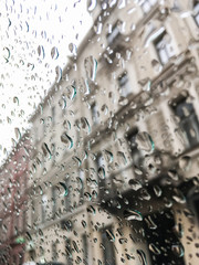 Drops Of Rain On Blue Glass Background. Street Bokeh Lights Out Of Focus. Autumn Abstract Backdrop
