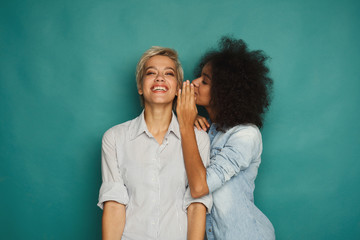 Young woman telling her friend some secrets