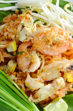 Pad Thai stir fried rice noodles with seafood and egg on plate