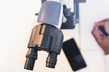 close up of man using microscope