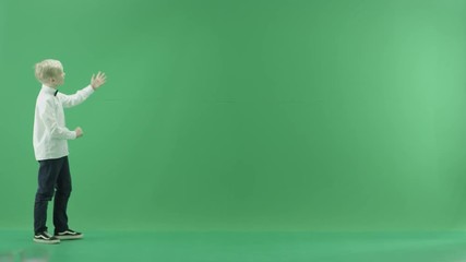 The child is going from the left side and showing the weather forecast on the green screen