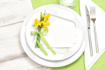 Spring table decoration narcissus flowers White plate fork knife