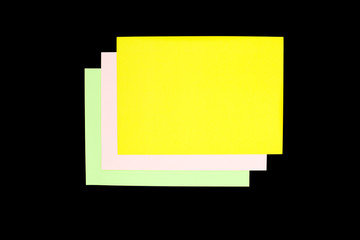 green, pink and yellow paper isolated on black background