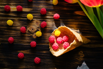 Blossoming red tulips on a wooden background with sweets.