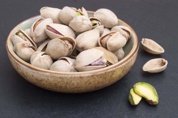 pistachios on black background in a bowl