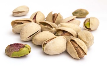 macro of pistachios on white background