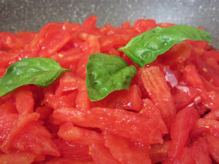 Cooking homemade tomato sauce using fresh summer tomatoes, onion, garlic and basil. Italian recipe