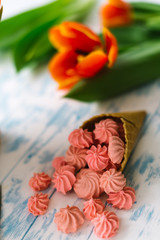 Blooming tulips near the horn with pink marshmallows
