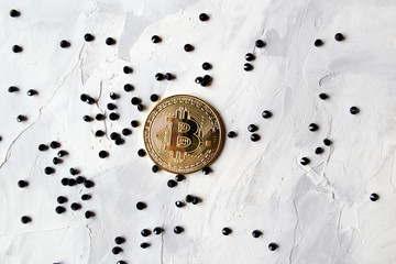 Golden bitcoin with black jewels on the white textured background.