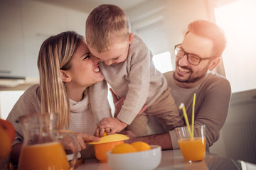 Obraz na płótnie Canvas Family make fresh orange juice in their kitchen.