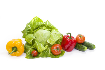 Fototapeta na wymiar Green cabbage. Yellow pepper. Red tomatoes and cucumbers on a white background. Composition from different vegetables on a white background.