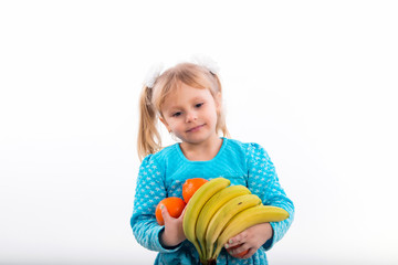 Child, little girl posing positively with bananas and oranges.