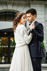 Bride and groom walking around among the houses and buildings