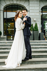 Wedding in a beautiful location. Wedding couple,bride and groom holding hands and going up the...