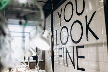Black lettering 'You Look Fine' on white wall'