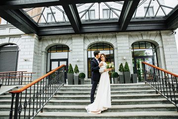 Wedding in a beautiful location. Wedding couple,bride and groom holding hands and going up the...