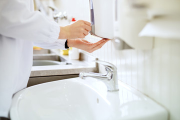 Close up view of a worker in sterile cloths washing hands a bathroom before working.
