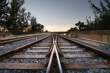 Fototapeta na wymiar Rails train towards the infinite in sunset
