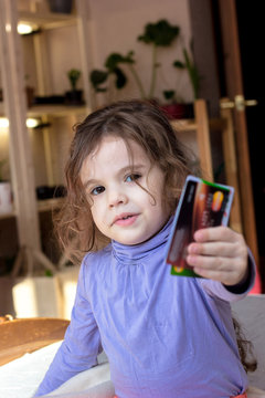 Young cute baby girl with credit cards in hands.