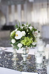 Bouquet of white roses and orchids on a table on a silver napkin