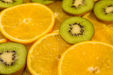 Naklejka na ściany i meble Background of the kiwi and orange fruits. Selective focus