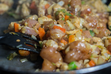 Cooking burrito in a pan with chicken, pepper, tomato for fajitas typical Latin America food
