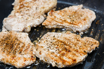 Pieces of roasted meat on knurled griddle