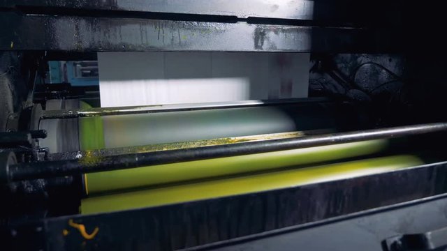 Fresh daily newspapers rolling on a printing equipment. 4K.