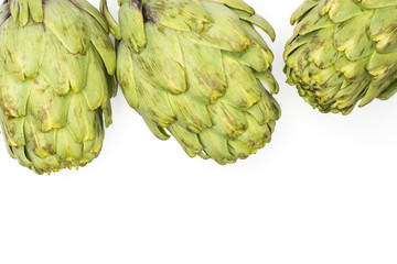 Three globe artichoke top view isolated on white background raw fresh green.