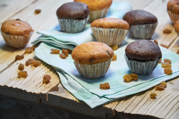 Chocolate and vanilla muffins with nuts on wooden background, selective focus