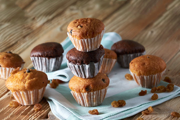 Chocolate and vanilla muffins with nuts on wooden background, selective focus