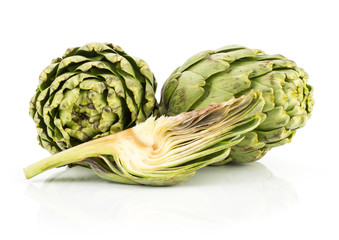Fototapeta premium Two globe artichoke heads and one slice isolated on white background fresh cut raw.