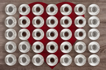 Collection of porcelain coffee cups on the background of red heart