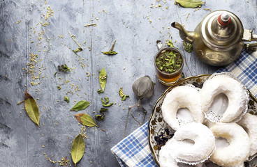 Oriental Algerian sweet cookies( gazelle horns cookies ), tea cup and pot  and mint leaves