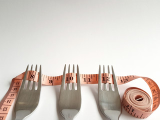Measuring tape and forks for dieting concept 