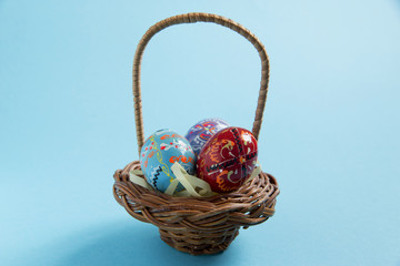 easter eggs painted in a basket on a blue background