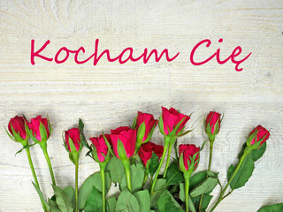 Roses on a wooden clear background and Kocham Cię © karolinaklink