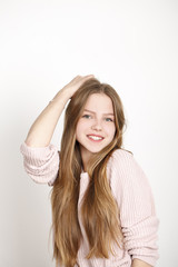 Fototapeta premium Close up portrait of pretty young schoolgirl with dark blonde hair smiling charmingly