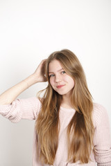 Close up portrait of pretty young schoolgirl with dark blonde hair smiling charmingly