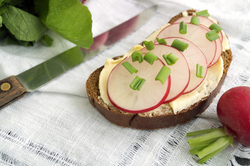 Bread with butter and radish on a wooden Board.