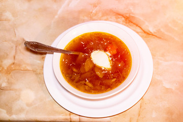 Soup with sour cream. There is a spoon in the plate