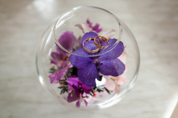 Wedding rings on the petal of purple orchid