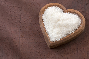 White sugar, refined and grainy in the heart-shaped bowl