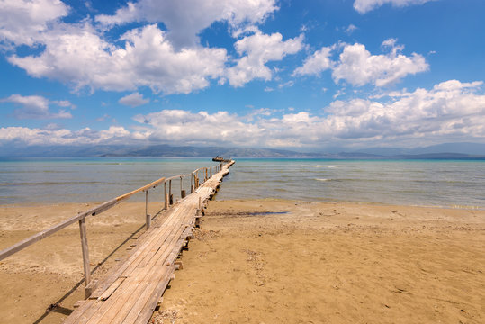 Wooden pier on sandy Apraos beach near Kassiopi town on Corfu island. Greece.