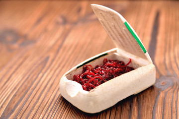 winterworm for winter fishing in a box on a brown wooden background