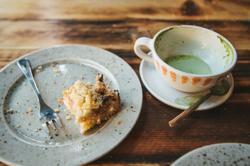 The concept of the completion of the holiday. A dirty plate and an empty cup of coffee. The half-eaten cupcake on a plate. Empty dishes after eating.